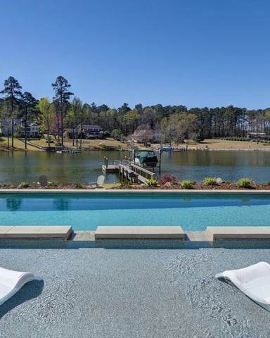 Outdoor pool with lounge chairs and lush landscaping